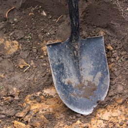 A close up of a shovel in the dirt.