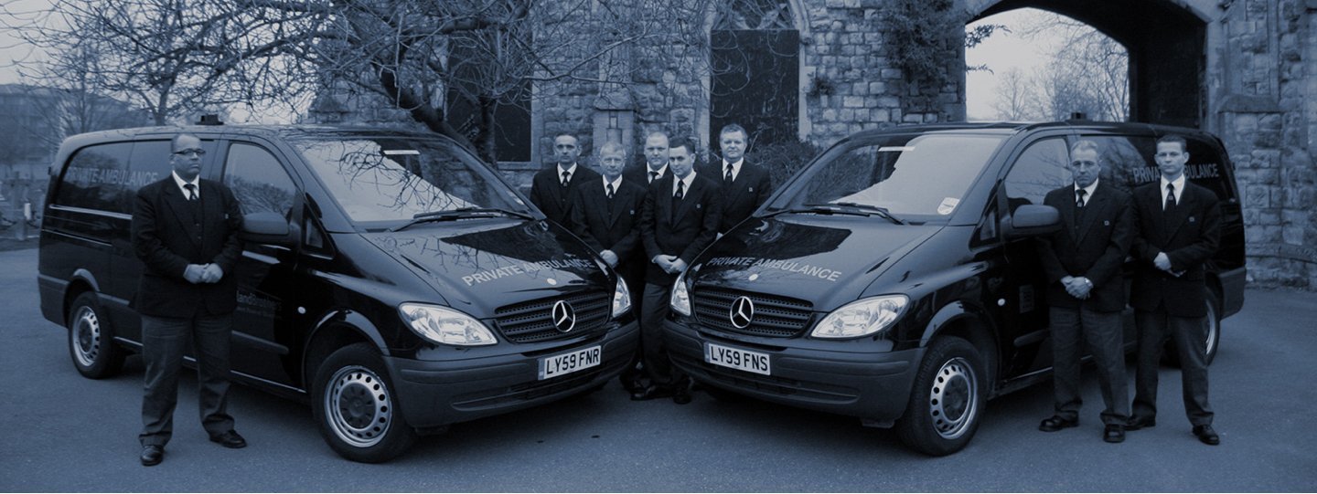 Image of the Rowland Brothers funeral directors team next to two private ambulances.